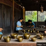 Home 19 금속공예 수출 전략 - A detailed scene showcasing a Vietnamese artisan workshop where skilled craftspeople are handcraftin...